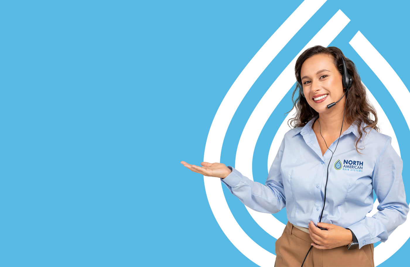 Woman in a blue shirt with a headset on, pointing to a logo on a blue background
