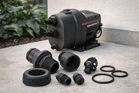 Gardena pump and accessories on a concrete surface with plants in the background